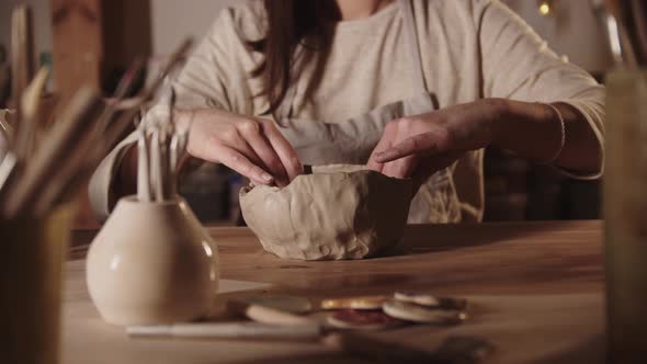 Young Woman Potter Forming a Bowl Out of Soft Clay with Her Hands