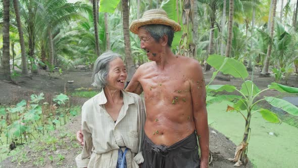 Portrait of Asian senior older couple farmer work in coconut farm with happy face and look to camera