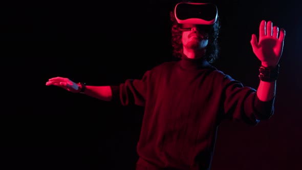 Man with VR Helmet on His Head Playing in Redblue Lights Online Party