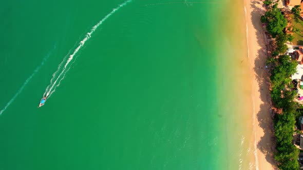 Aerial top view over sandy beach with turquoise water