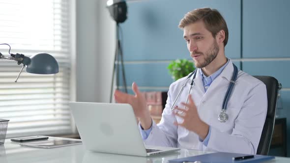 Doctor Talking on Video Call on Laptop in Office