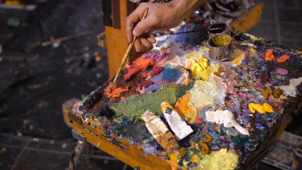 Artist Mixes Oil Paints On Pallet With Various Colors
