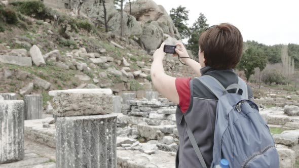 Tourist Photographing Ruins of Ancient Temple