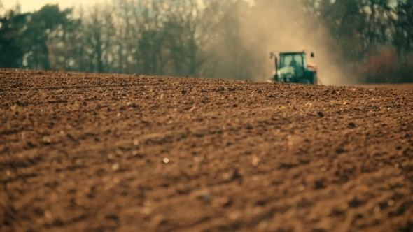 Tractor Plowing Field At Sunset