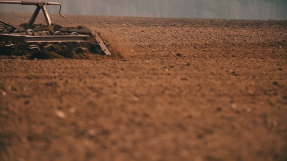 Tractor Plowing Field At Sunset