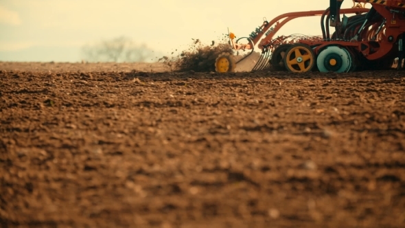 Tractor Plowing Field At Sunset