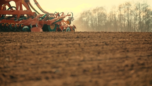 Tractor Plowing Field At Sunset