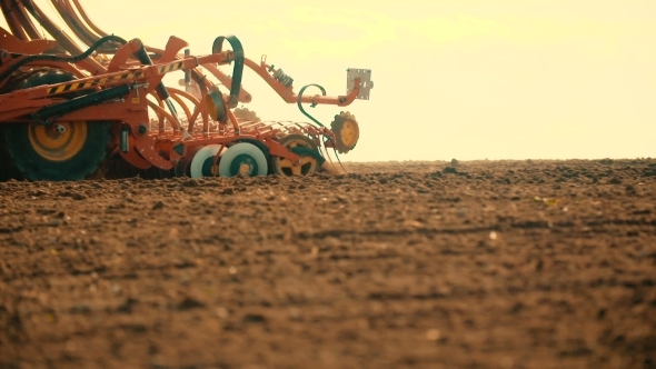 Tractor Plowing Field At Sunset