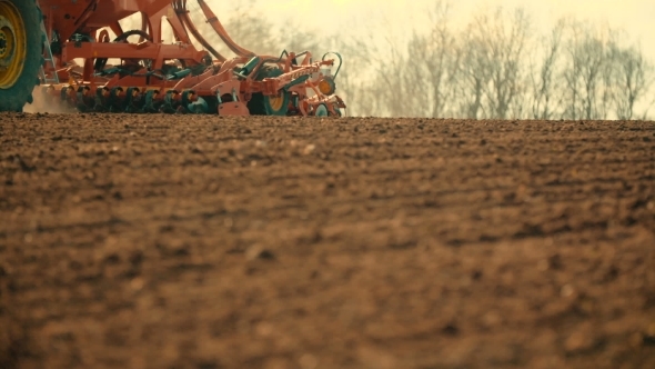 Tractor Plowing Field At Sunset