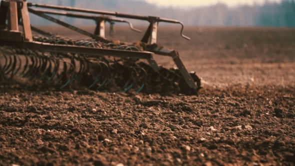 Tractor Plowing Field At Sunset