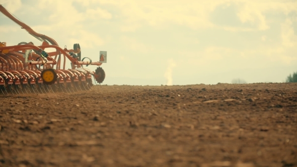 Tractor Plowing Field At Sunset