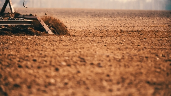 Tractor Plowing Field At Sunset