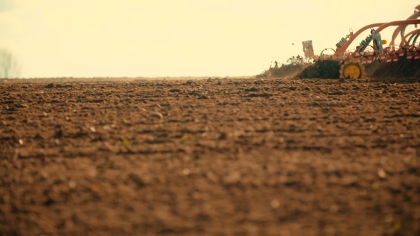 Tractor Plowing Field At Sunset