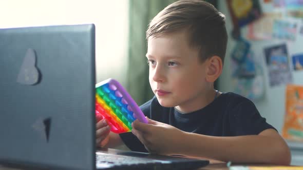 Caucasian boy in front of a laptop at home