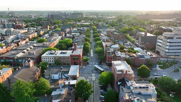 American city aerial pullback reveal at golden hour. Residential community in summer sunset. Reverse