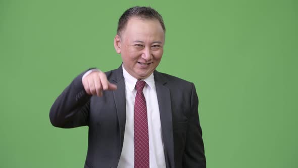 Mature Happy Japanese Businessman Pointing at Camera