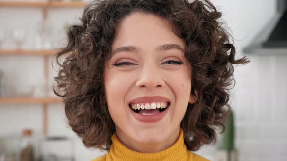 Close Up Face Smiling Hispanic Curly Woman Looking Camera at Home Kitchen