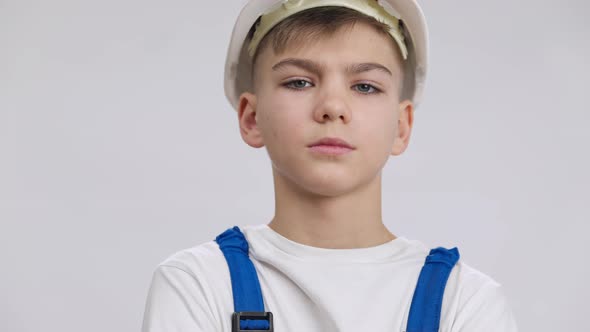 Closeup Unhappy Caucasian Boy Looking at Camera with Dissatisfied Facial Expression Posing at White