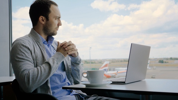 Man thinking while waiting for his flight in the international