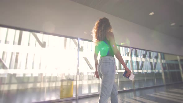 Girl Standing at the Window in Airport Before Boarding the Plane