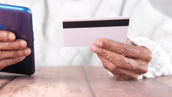 Senior Women Hand Holding Credit Card and Using Smart Phone Shopping Online