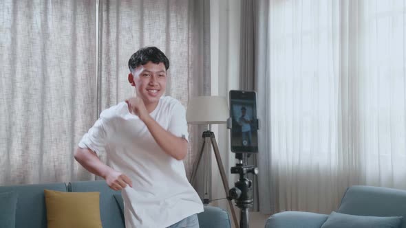 Asian Boy Dancing While Shooting Video Content For Social Networks With A Smartphone Camera