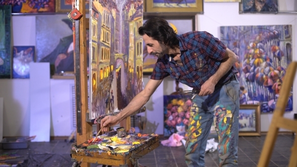 The Creation Of a Masterpiece. Senior Man Painting On a Canvas alt