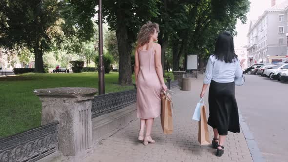 Back View of Two Women Walking in the Summer City Together
