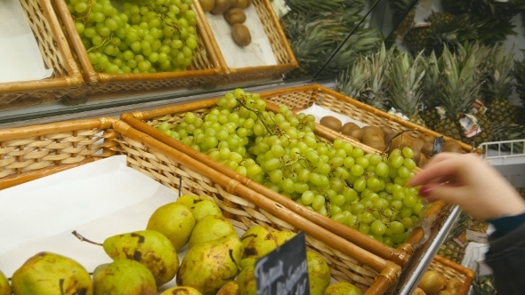Female Hand Choosing Grapes At The Store 