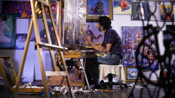 In a Cozy Atmosphere. Artist Painting Picture In Workshop  alt