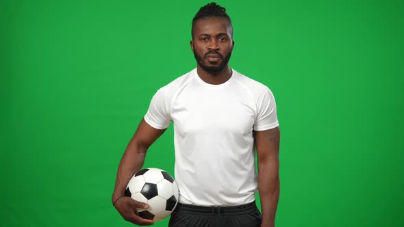 Medium Shot Portrait of Confident African American Man with Football Ball Posing at Background of