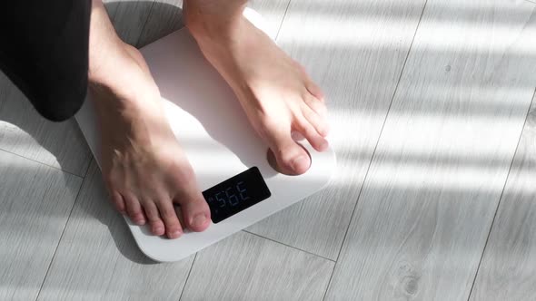 Man Legs Stepping on Floor Scales at Home.