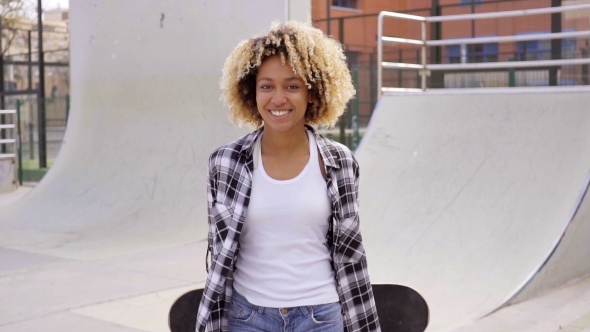 Charismatic Young Woman Holding a Skateboard