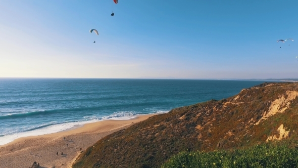 Paragliders Fly Over The Ocean Beach