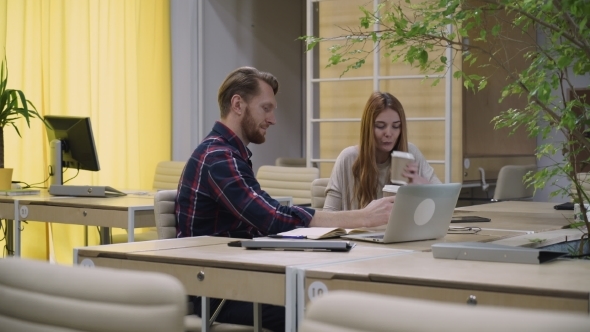 Two Staff Members Sit In The Office And Drinking Your Morning Coffee. alt