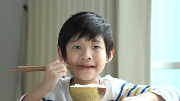 Cute Asian Boy Eating Rice With Chopsticks