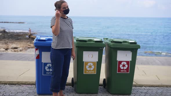 Confident Caucasian Young Woman Taking Off Coronavirus Face Mask Throwing Garbage in Plastic Waste