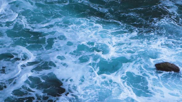 Dark Blue Sea Waves Crashing on the Rocks with White Foam in Slow Motion