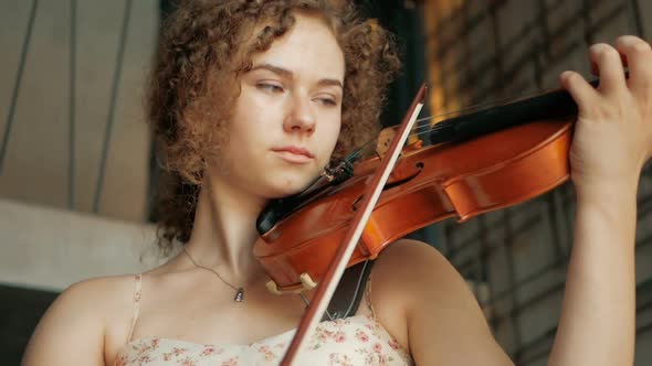 young curly blond woman the violinist: Musician playing violin