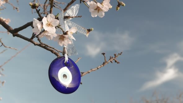 Evil Eye Amulet Hangs on a Blossoming Tree