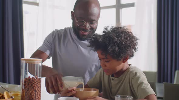African American Man Taking Care of Kid on Breakfast at Home