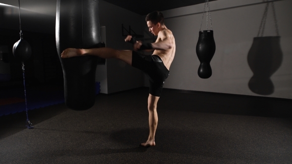 Muscular Handsome Fighter Giving a Forceful Forward Kick 