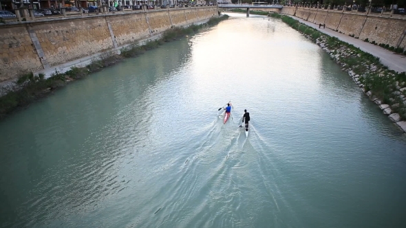 Paddling Two Boats In a River.