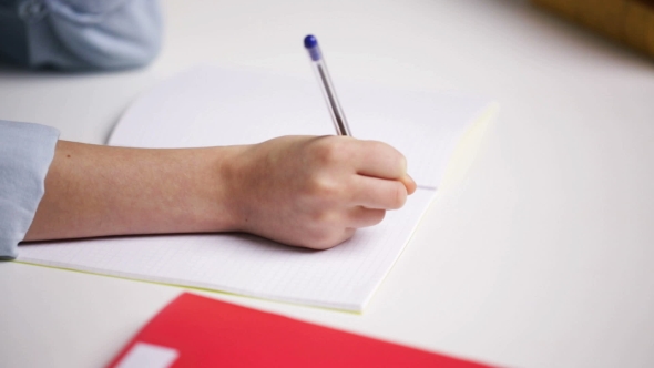 School Girl Hand Writing Math Task To Notepad