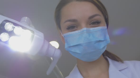 Young Dentist in Mask is Holding a Tools Standing