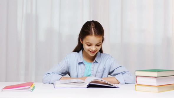Happy School Girl Reading Book Or Textbook At Home