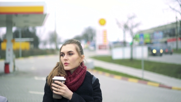 Beautiful Girl Drinks Coffee At a Gas Station