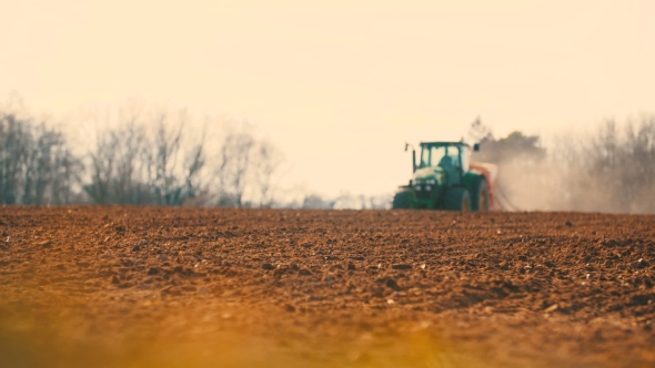 Tractor Plowing Field At Sunset