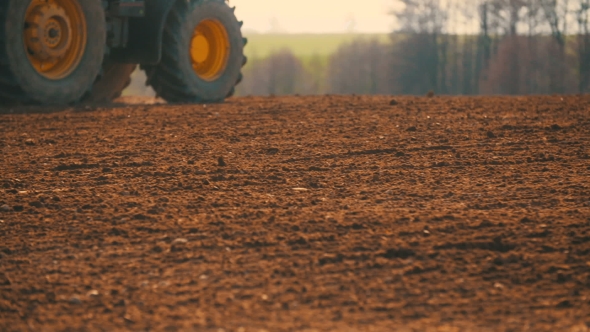 Tractor Plowing Field At Sunset