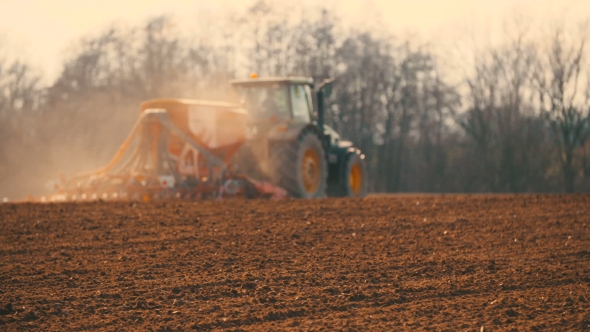 Tractor Plowing Field At Sunset